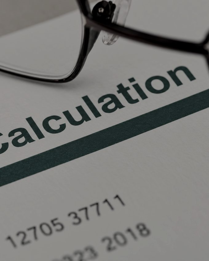 A printed tax calculation with reading glasses